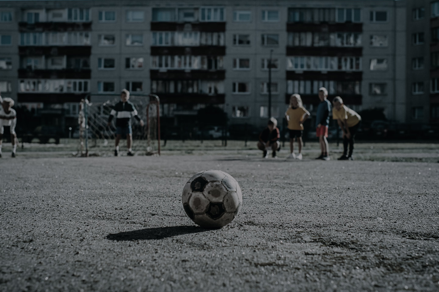 Football resting on a grassroots pitch before a community game